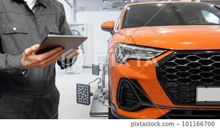 Serviceman with digital tablet on the background of the car in the car service 101166700