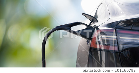 Close up of electric car inlet with a connected charging cable on a green background Close up of electric car inlet with a connected charging cable on a green background 101166792