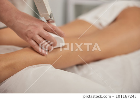 Correction cellulite, roller massage, figure correction. Young woman with body shaping machine, masseur massages client with vacuum roller, figure correction massage anti-cellulite massage Correction cellulite, roller massage, figure correction. Young woman with body shaping machine, masseur massages client with vacuum roller, figure correction massage anti-cellulite massage 101167245