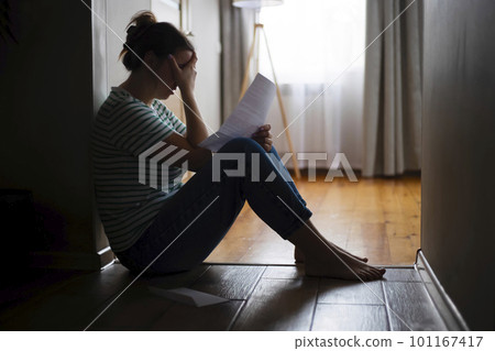 Silhouette of sad and depressed woman sitting on the floor at home Silhouette of sad and depressed woman sitting on the floor at home 101167417