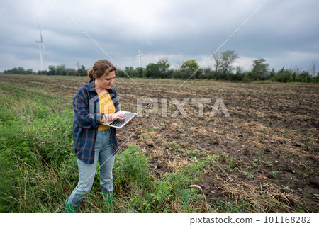 Farmer with laptop on the field. 101168282