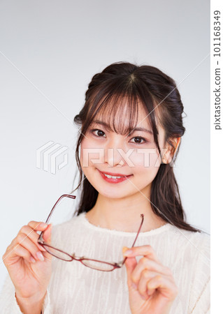 A young woman at an ophthalmologist takes off her glasses for a vision test [ Image of LASIK ] 101168349