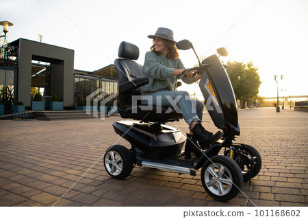 Woman tourist riding a four wheel mobility electric scooter 101168602