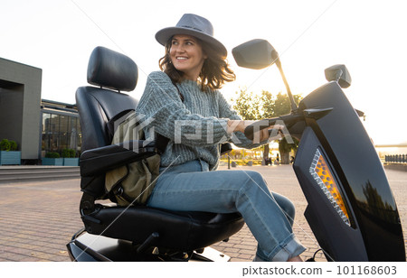 Woman tourist riding a four wheel mobility electric scooter 101168603