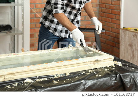 Man repairing old damaged window at table indoors, closeup 101168737