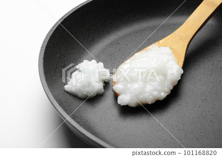 Frying pan with coconut oil and wooden spoon on white background, closeup. Healthy cooking Frying pan with coconut oil and wooden spoon on white background, closeup. Healthy cooking 101168820
