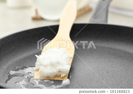 Frying pan with coconut oil on induction stove, closeup. Healthy cooking 101168823
