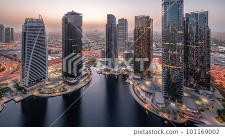 Tall residential buildings at JLT aerial night to day timelapse, part of the Dubai multi commodities centre mixed-use district. 101169002