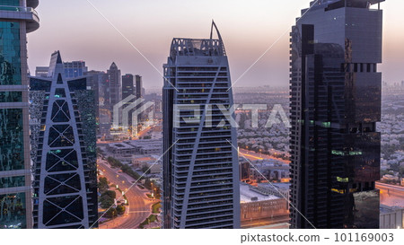 Tall residential buildings at JLT aerial night to day timelapse, part of the Dubai multi commodities centre mixed-use district. 101169003