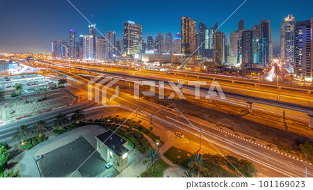 Dubai Marina skyscrapers and Sheikh Zayed road with metro railway aerial day to night timelapse, United Arab Emirates 101169023