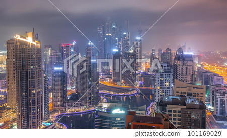 View of various skyscrapers in tallest recidential block in Dubai Marina aerial all night timelapse 101169029