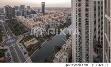 Pond and low rise buildings in Greens district aerial night to day timelapse. 101169124