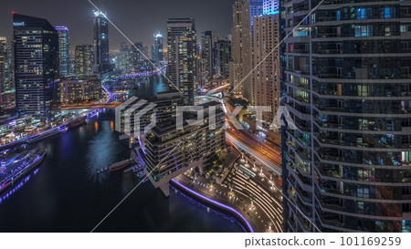 Aerial view to Dubai marina skyscrapers around canal with floating boats night timelapse 101169259