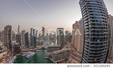Aerial view to Dubai marina skyscrapers around canal with floating boats day to night timelapse Aerial view to Dubai marina skyscrapers around canal with floating boats day to night timelapse 101169265