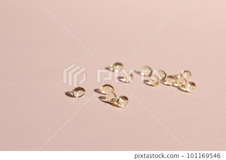 Omega 3 or vitamin D gel capsules scattered on pink pastel background with copy advertising space. Gelatin capsules with essential oils or acids. Health care, medicine and pharmacy concept Omega 3 or vitamin D gel capsules scattered on pink pastel background with copy advertising space. Gelatin capsules with essential oils or acids. Health care, medicine and pharmacy concept 101169546