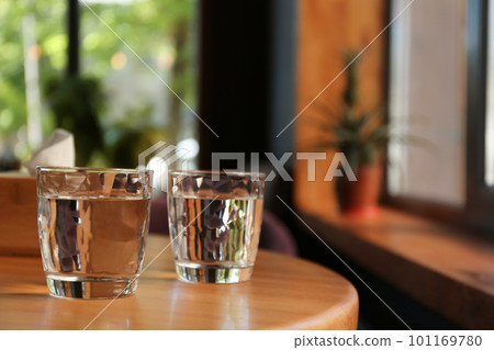 Glasses of water on wooden table in cafe. Space for text 101169780