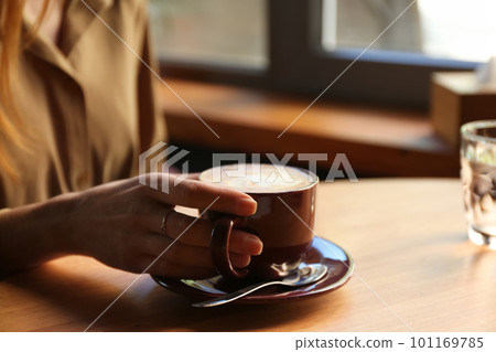 Woman with aromatic coffee at table in cafe, closeup 101169785