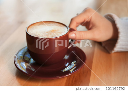 Woman with aromatic coffee at table in cafe, closeup 101169792