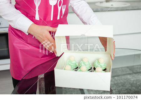 confectioner packs cupcakes in box, sending to customer, home business, entrepreneurship. confectioner packs cupcakes in box, sending to customer, home business, entrepreneurship. 101170074