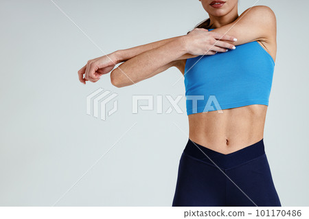 Close up of woman doing warm up hands exercises and stretching her body preparing to gym in studio 101170486