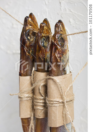Putassu Cold smoked. Hanging on a string. The fish is wrapped with a strip of paper. Tied with linen twine. Close-up. Putassu Cold smoked. Hanging on a string. The fish is wrapped with a strip of paper. Tied with linen twine. Close-up. 101170508