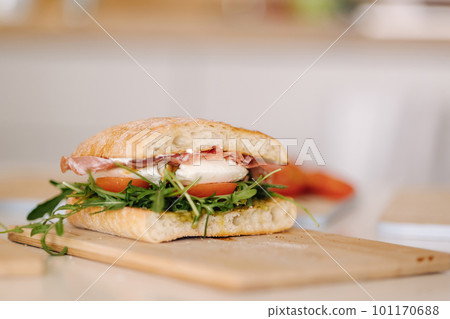 Tasty bruschetta on wooden board. Classic Italian lunch. Baguette with tomatoes, mozzarella and olive oil 101170688