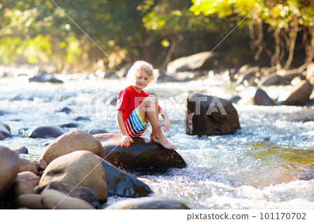 Child hiking in mountains. Kids at river shore. 101170702