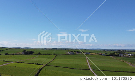 Clear blue sky over the green fields of southern Ireland. Picturesque summer landscape, sunny day. Green grass field under blue sky Clear blue sky over the green fields of southern Ireland. Picturesque summer landscape, sunny day. Green grass field under blue sky 101170850