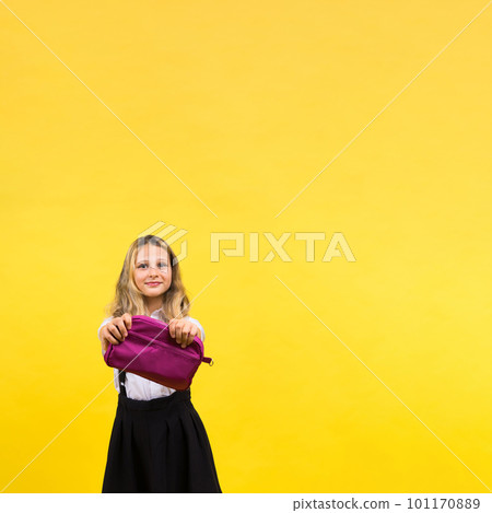 Little teenager girl with pencil case on yellow background Little teenager girl with pencil case on yellow background 101170889
