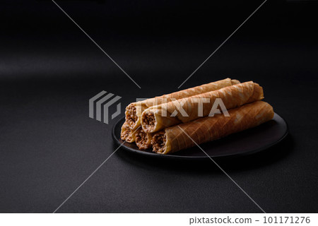 Delicious crispy wafer rolls with cream filling with nuts Delicious crispy wafer rolls with cream filling with nuts 101171276