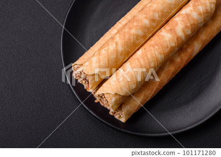 Delicious crispy wafer rolls with cream filling with nuts Delicious crispy wafer rolls with cream filling with nuts 101171280