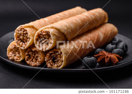 Delicious crispy wafer rolls with cream filling with nuts 101171286