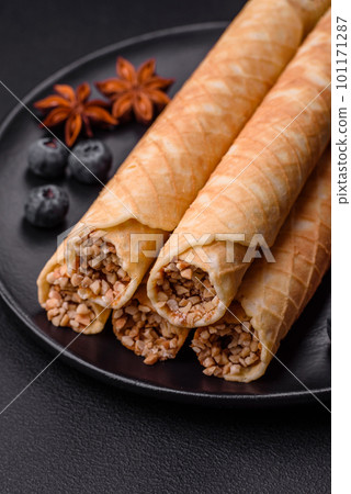 Delicious crispy wafer rolls with cream filling with nuts 101171287
