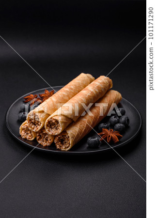 Delicious crispy wafer rolls with cream filling with nuts Delicious crispy wafer rolls with cream filling with nuts 101171290