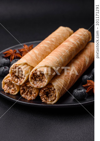 Delicious crispy wafer rolls with cream filling with nuts Delicious crispy wafer rolls with cream filling with nuts 101171291
