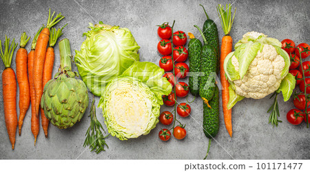 Fresh assorted organic vegetables arranged in line on rustic grey stone table top view. Vegetarian food background and healthy vegetable ingredients with vitamins concept, diet and clean eating Fresh assorted organic vegetables arranged in line on rustic grey stone table top view. Vegetarian food background and healthy vegetable ingredients with vitamins concept, diet and clean eating 101171477
