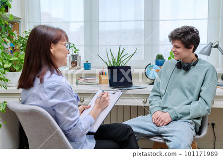 Woman social worker, mentor interviewing, talking to young male in office Woman social worker, mentor interviewing, talking to young male in office 101171989