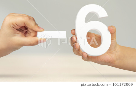 Minus six. The number six and the minus symbol in a hand close-up on a light gray background. The concept of removal or taking away 101172009