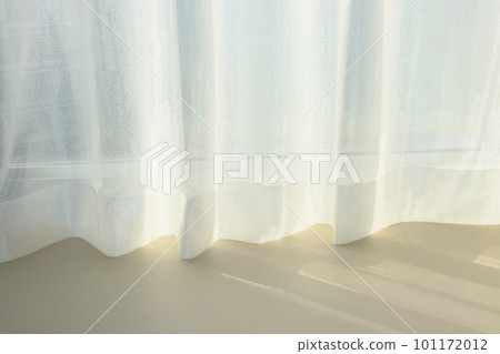 A room with a window where the sun shines and a curtain 101172012