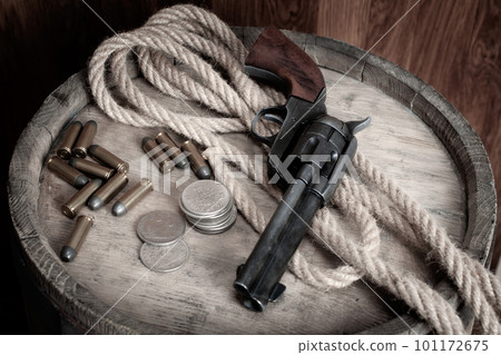 Old west revolver with cartridges and silver dollar coins 101172675
