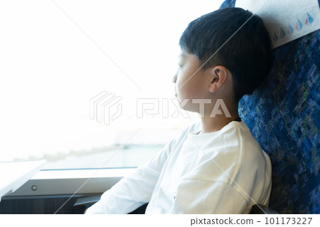 Elementary school boy looking out of the train window 101173227