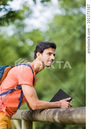 indian south asian backpacker. Thinking with happiness expression in an Asturias environmental Travel. indian south asian backpacker. Thinking with happiness expression in an Asturias environmental Travel. 101173387