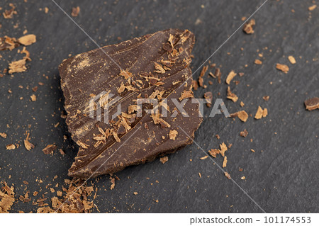 a crumbled piece of bitter chocolate into small pieces a crumbled piece of bitter chocolate into small pieces 101174553
