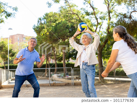 Old multinational people playing volleyball activity on a summer playground for sports in spring outside Old multinational people playing volleyball activity on a summer playground for sports in spring outside 101177630