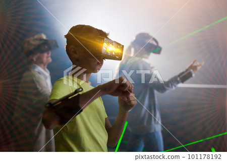 Boy in VR headset playing games with his family 101178192