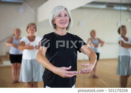 Aged women performing ballet dance in fitness room Aged women performing ballet dance in fitness room 101178206