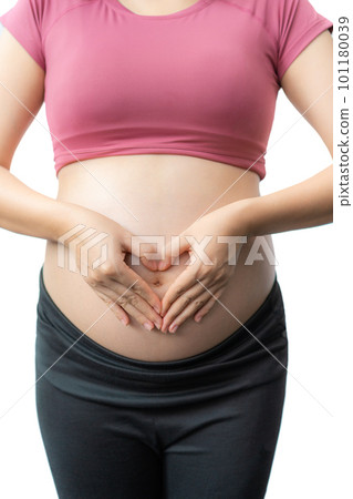 Close up of the happy pregnant woman in fitness clothes using her hands to make a heart shape over her exposed belly Close up of the happy pregnant woman in fitness clothes using her hands to make a heart shape over her exposed belly 101180039