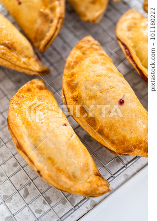 Freshly baked sweet cherry empanadas in the air fryer on the kitchen counter. 101180222