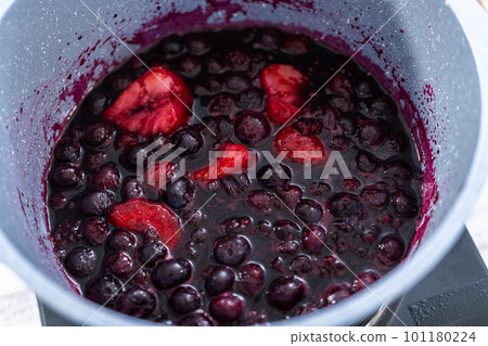 Preparing mixed berry compote from frozen berries in a nonstick cooking pot. Preparing mixed berry compote from frozen berries in a nonstick cooking pot. 101180224
