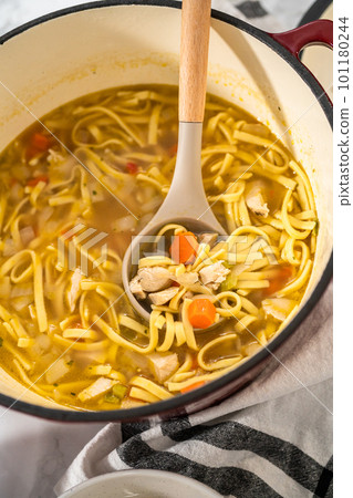 Serving chicken noodle soup with kluski noodles in white ceramic soup bowls. Serving chicken noodle soup with kluski noodles in white ceramic soup bowls. 101180244